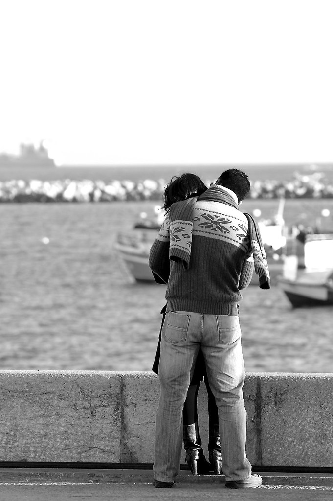 Abbraccio da dietro mentre si guarda il mare