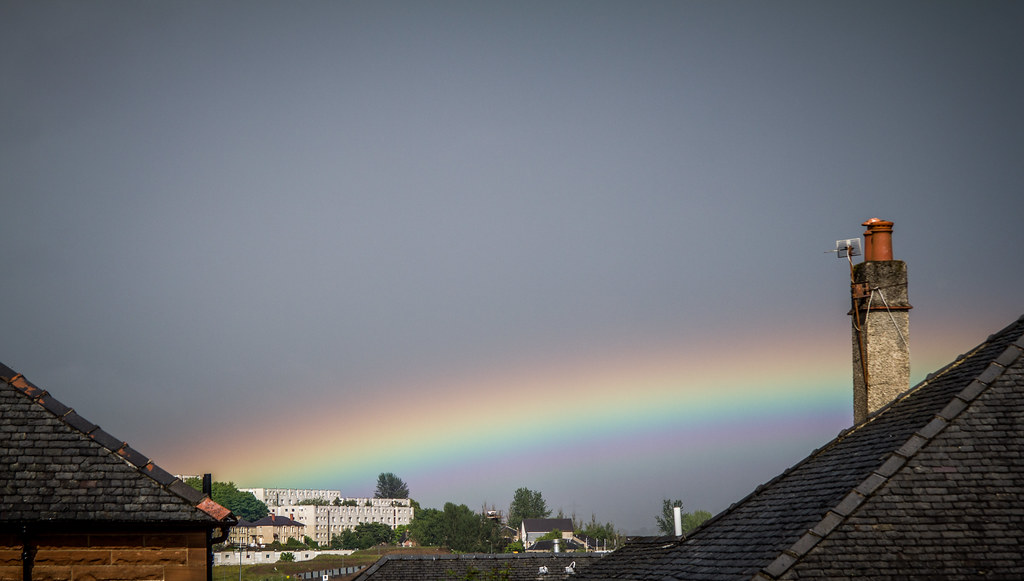 Arco di arcobaleno tra tetti di case