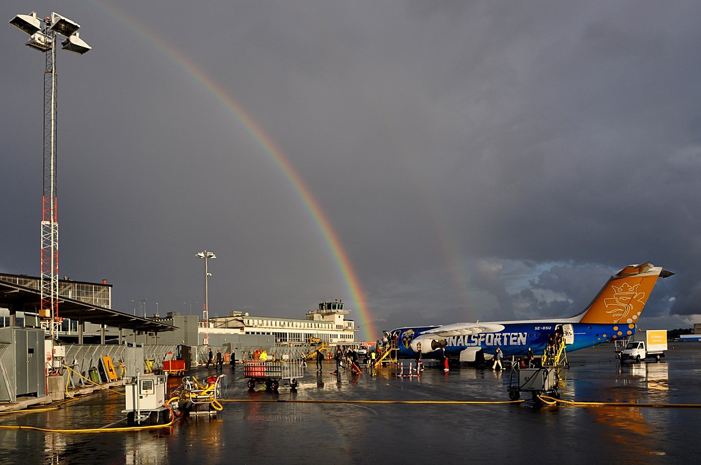 Arcobaleno che nasce da pista di atterraggio di aerei