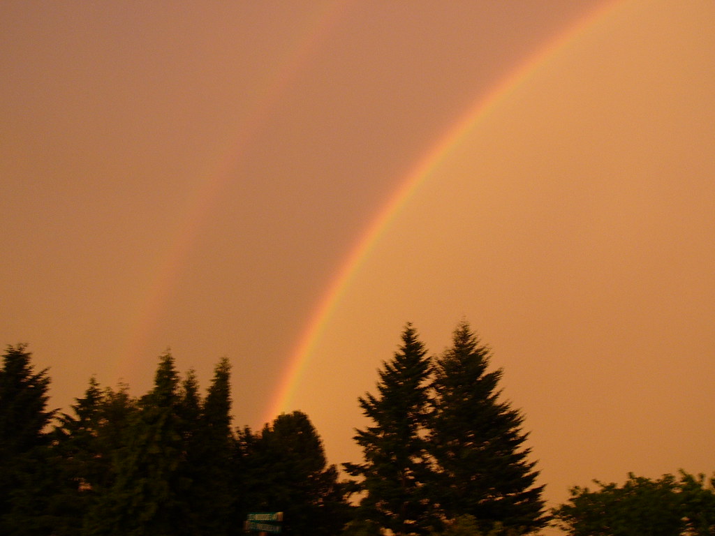 Arcobaleno che si confonde in cielo arancione