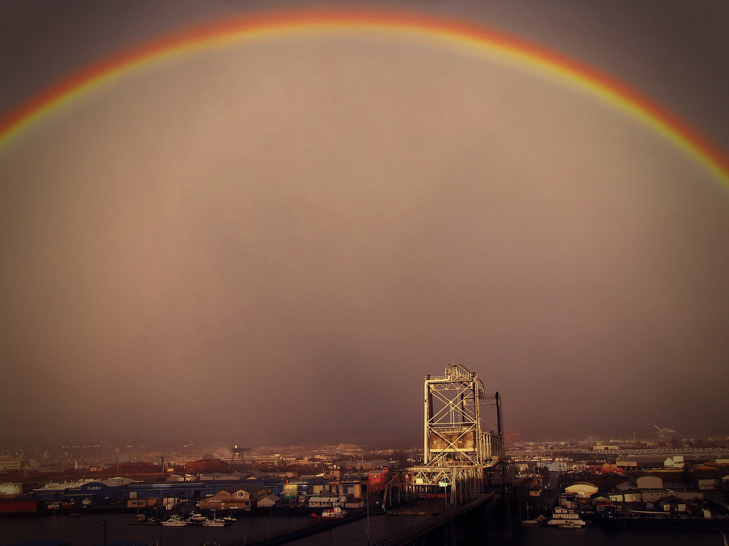 Arcobaleno con dominante color arancio sulla città