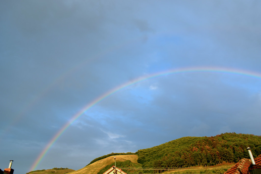 Arcobaleno con minuscolo doppio in cielo celeste