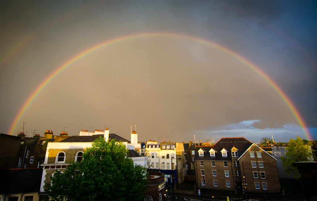 Arcobaleno con sotto luce giallina che illumina città