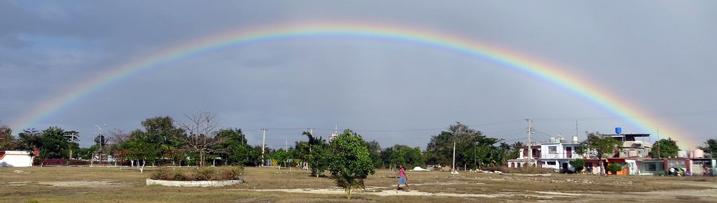 Arcobaleno intero sopra il verde e le case