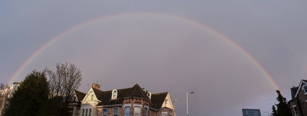 Arcobaleno intero sopra villa e strada