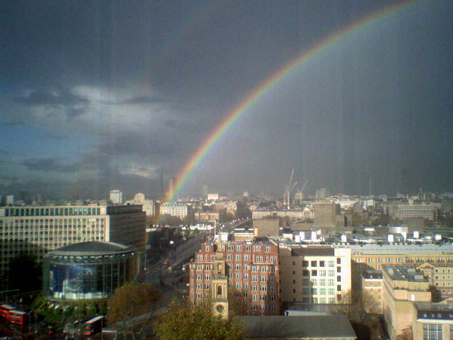 Arcobaleno molto alto sopra la città dopo la tempesta