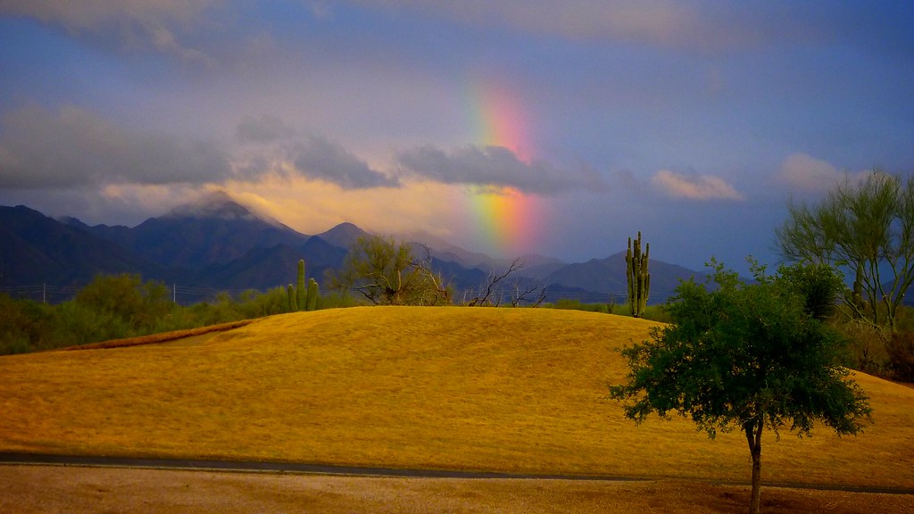 Arcobaleno spezzato da una nuvola in paesaggio molto pittoresco