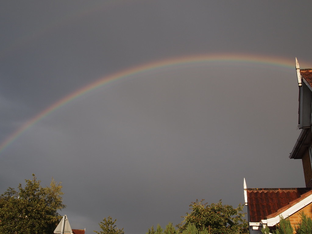 Arcobaleno tra i tetti delle case della città