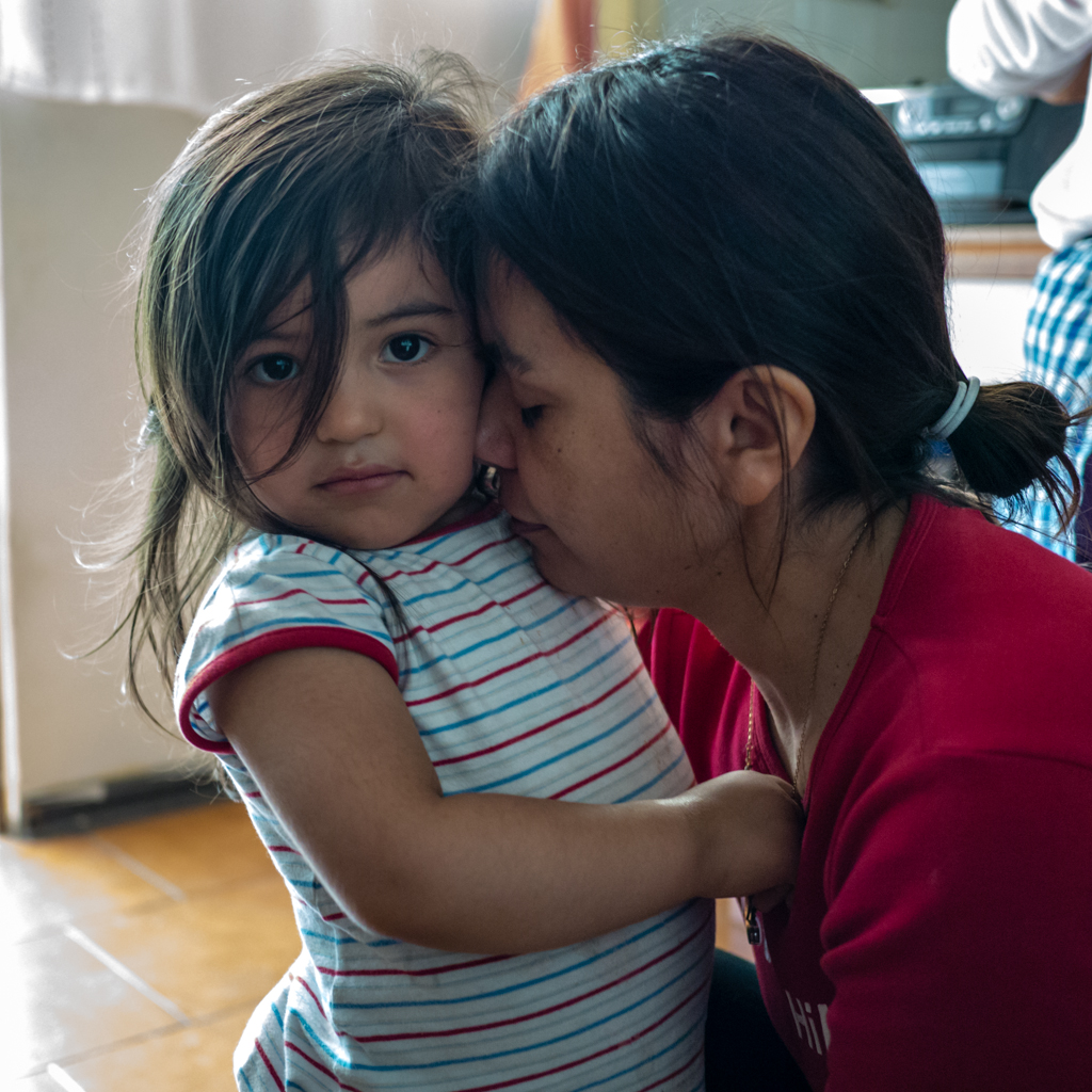 Bambina adorabile con occhi dolci coccolata dalla madre