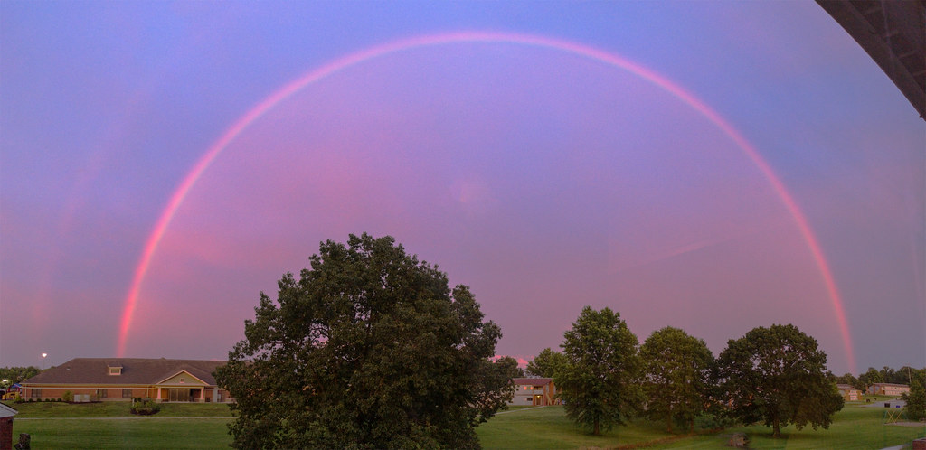 Bellissimo arcobaleno rossastro che forma una cupola