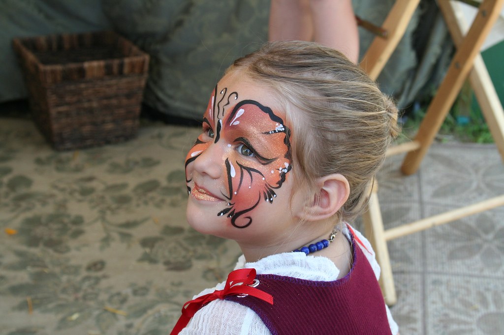 Dolce bimba con farfalla disegnata sul volto