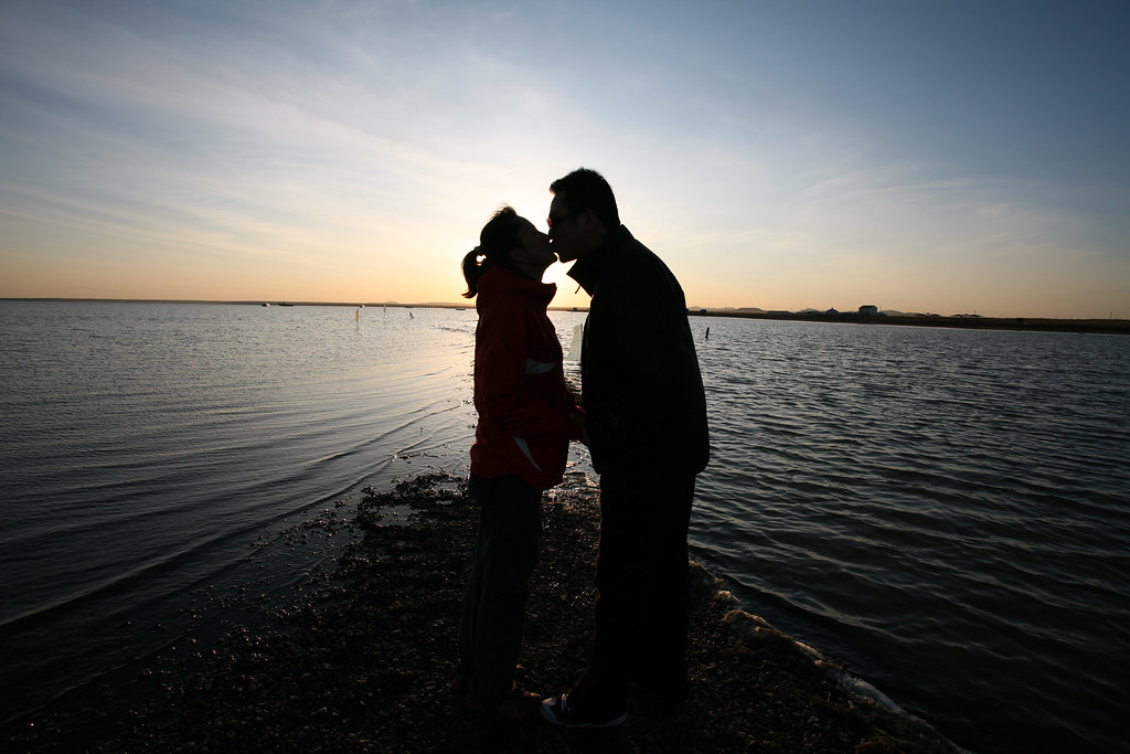 Dolce e romantico bacio al mare al tramonto