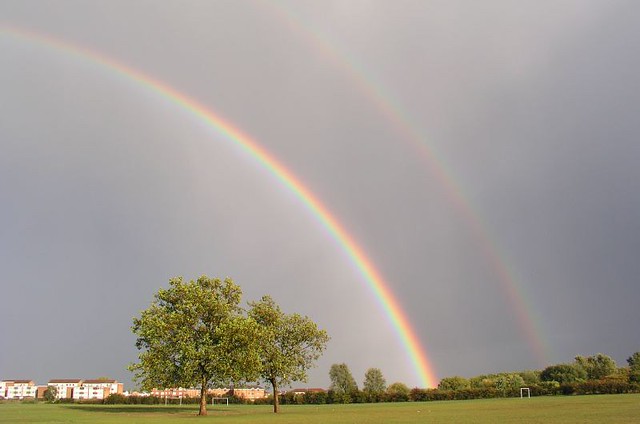 Doppio arcobaleno in grande cielo grigio