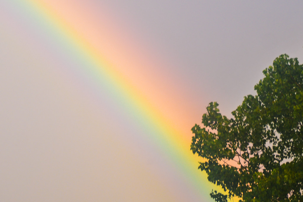 Luce di arcobaleno simile a saetta che squarcia il cielo