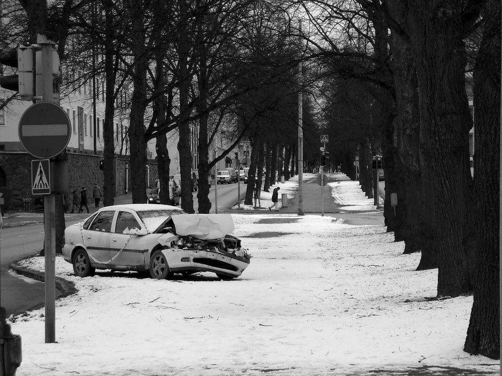 Macchina fracassata su strada innevata tra alberi spogli a helsinki