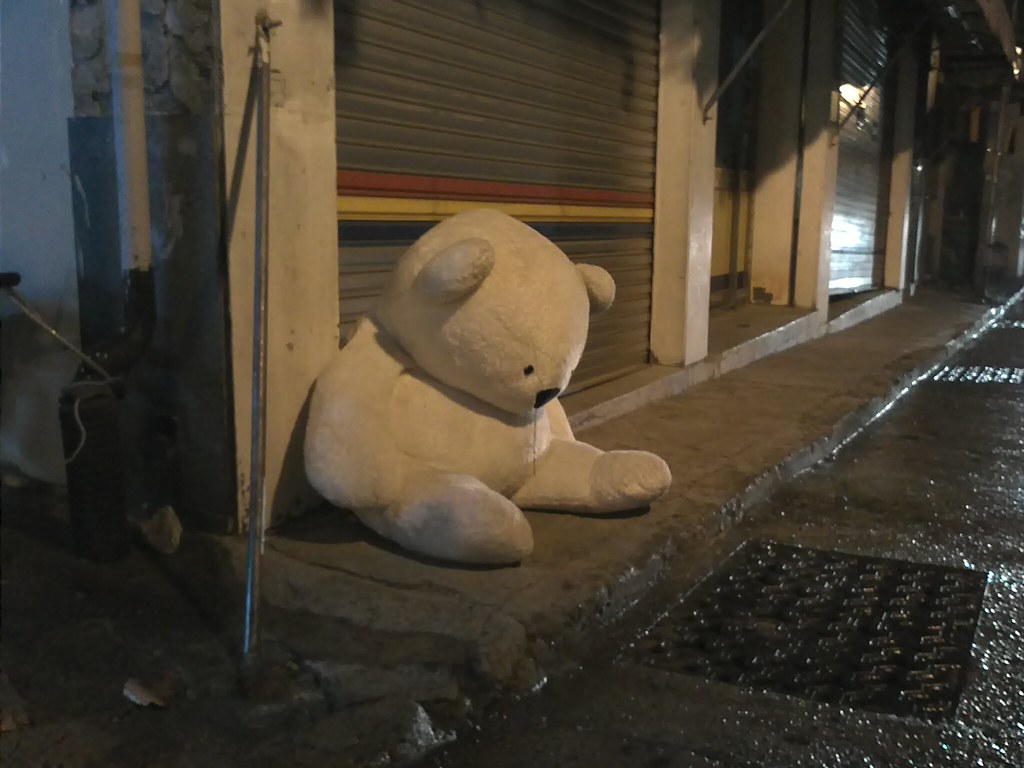 Orsacchiotto bianco gigante solo e triste su un marciapiede