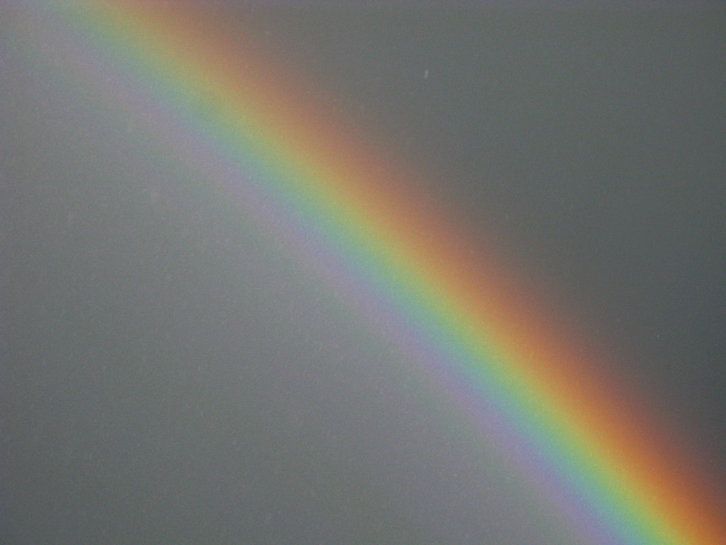 Parte di arcobaleno in diagonale nel grigio cielo