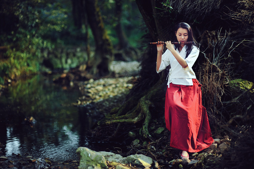 Ragazza che suona flauto in bosco in stile fantasy