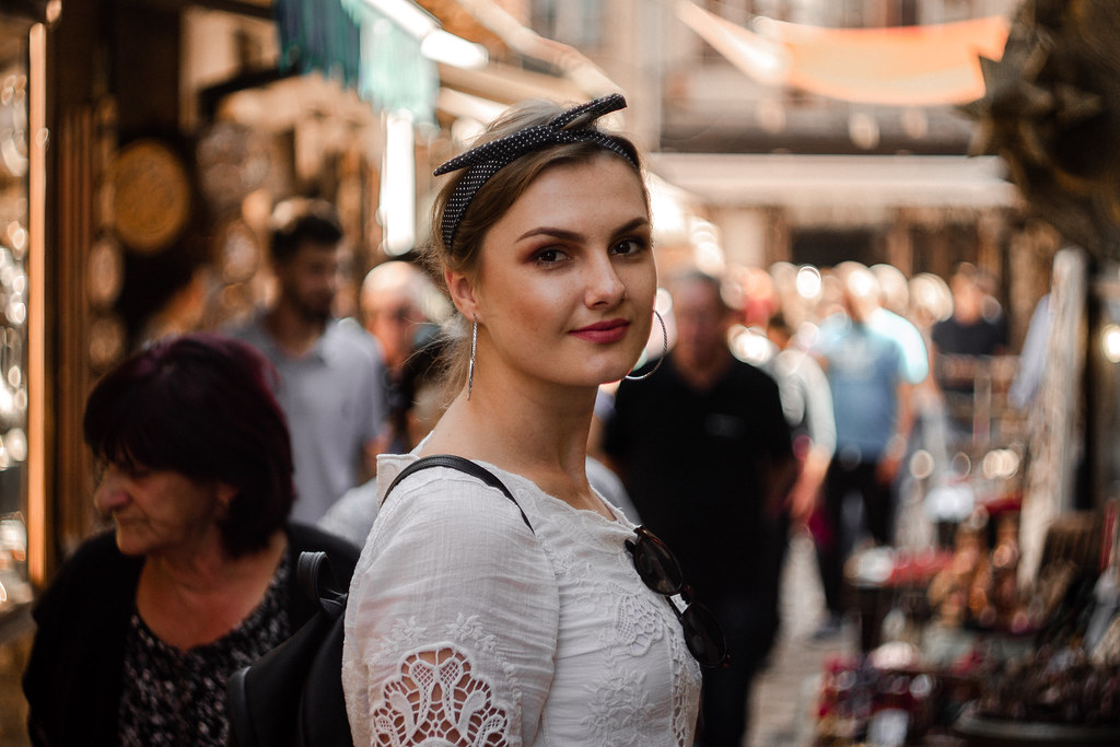 Ragazza con bel vestito bianco in mezzo alla folla