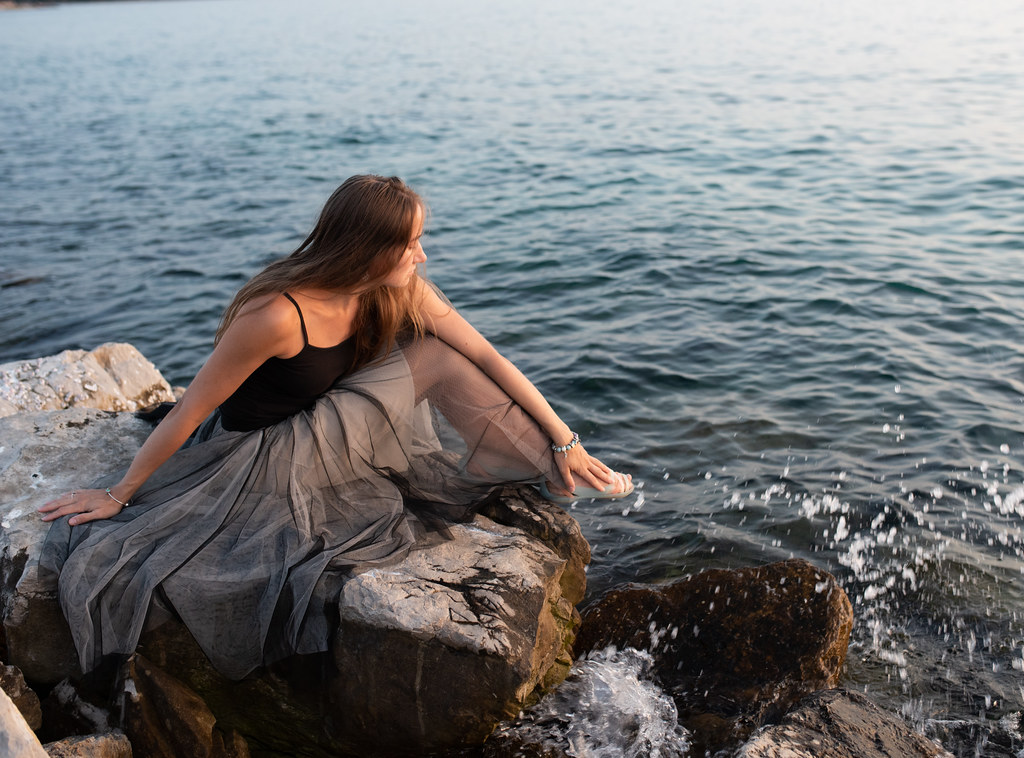 Ragazza in Croazia su scoglio che ammira il mare