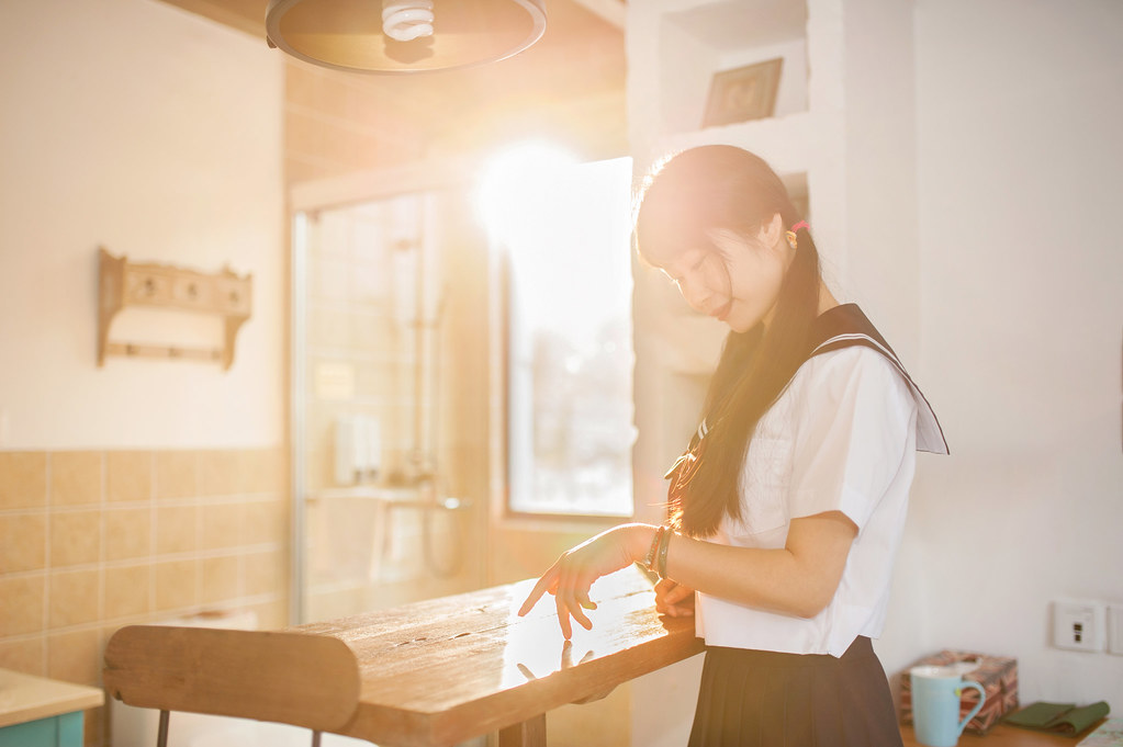 Ragazza orientale con divisa da studentessa in controluce