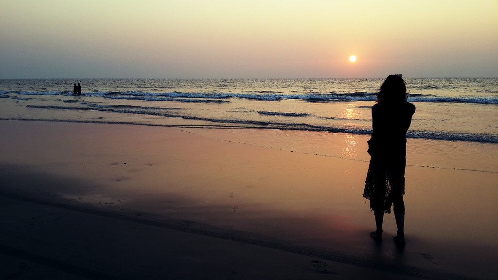 Ragazza sulla spiaggia in India al tramonto