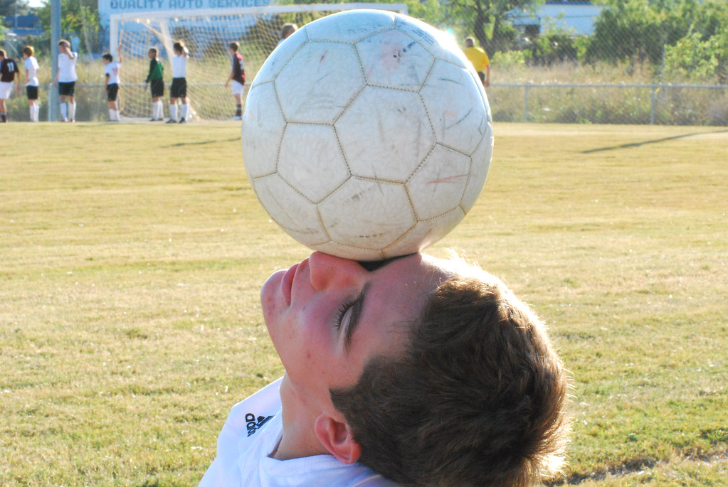 Ragazzo con pallone in equilibrio su un occhio