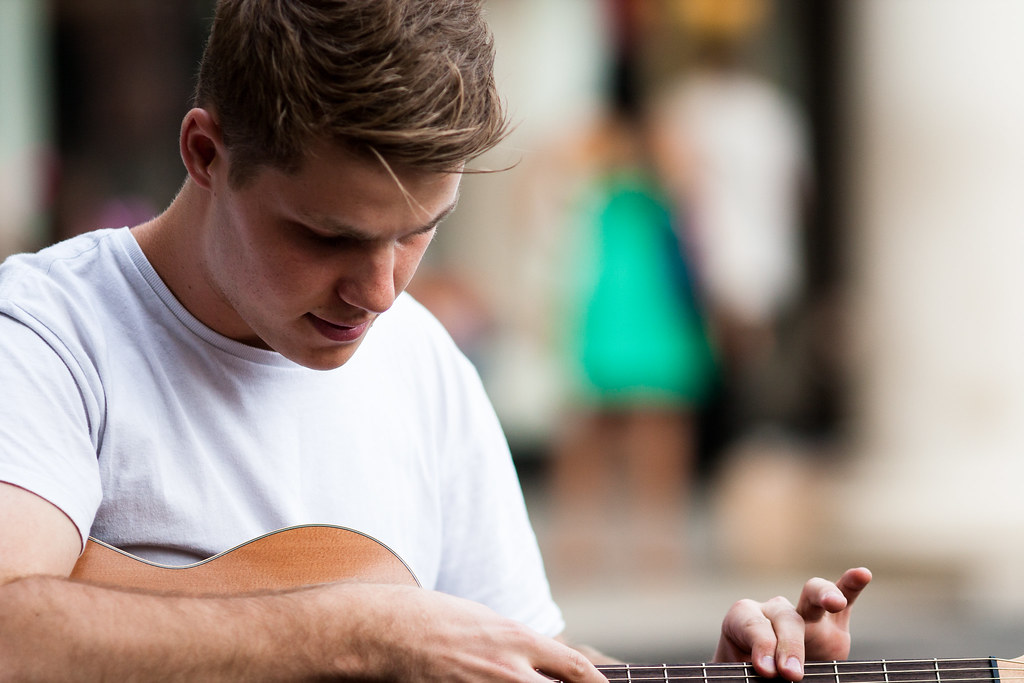 Ragazzo in maglietta che suona la chitarra