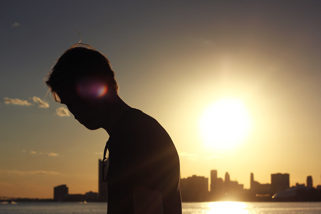 Ragazzo in ombra per controluce con skyline in lontananza