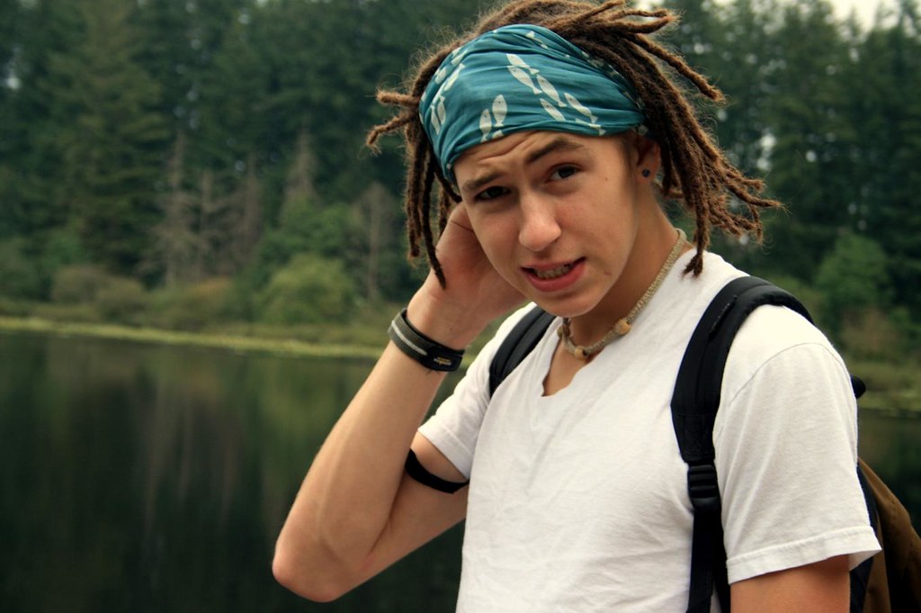 Ragazzo rasta al lago con fascia celeste che raccoglie capelli