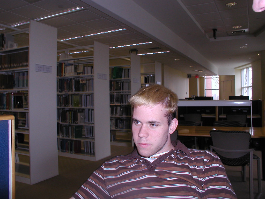 Ragazzo seduto concentrato in biblioteca