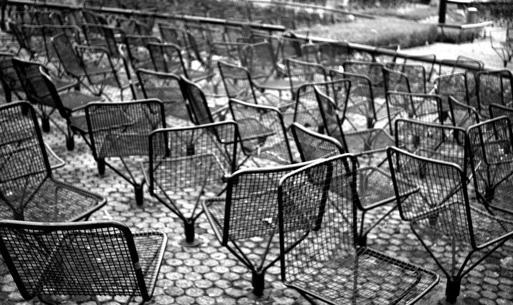 Sedie metalliche alla rinfusa su terrazza che fanno tristezza