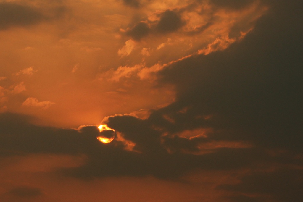 Sole che si nasconde tra le nuvole minacciose al tramonto