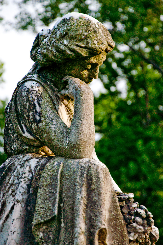 Statua di donna pensierosa che si sorregge il viso con una mano