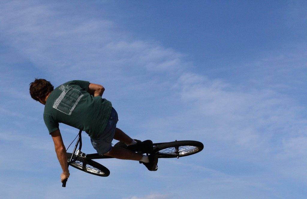 Talentuoso ragazzo in bicicletta BMX che sembra volare in cielo