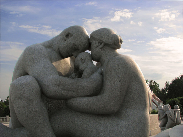 Tenero abbraccio tra statue tra bambino e genitori