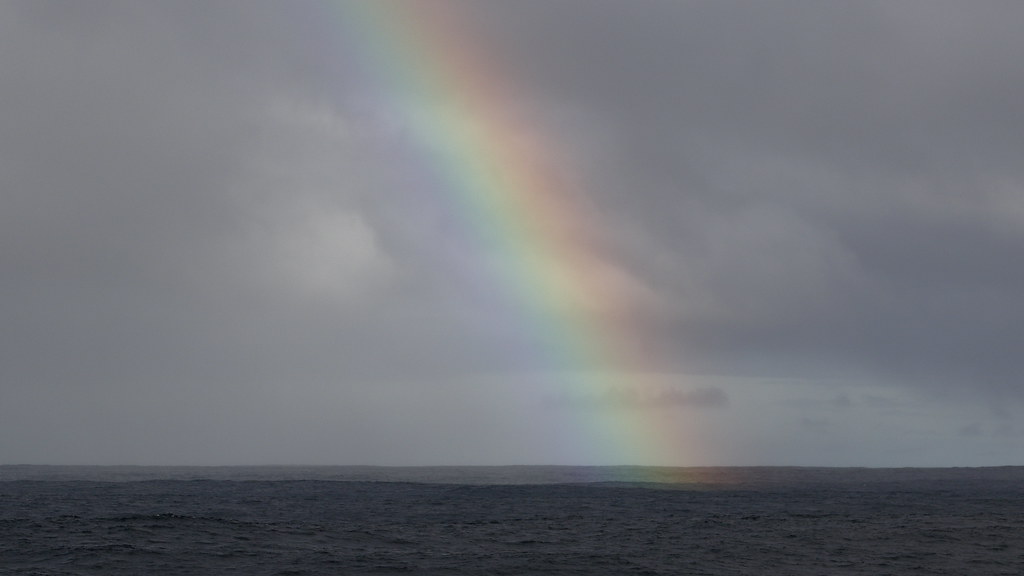 Tenue arcobaleno sul vasto mare scuro