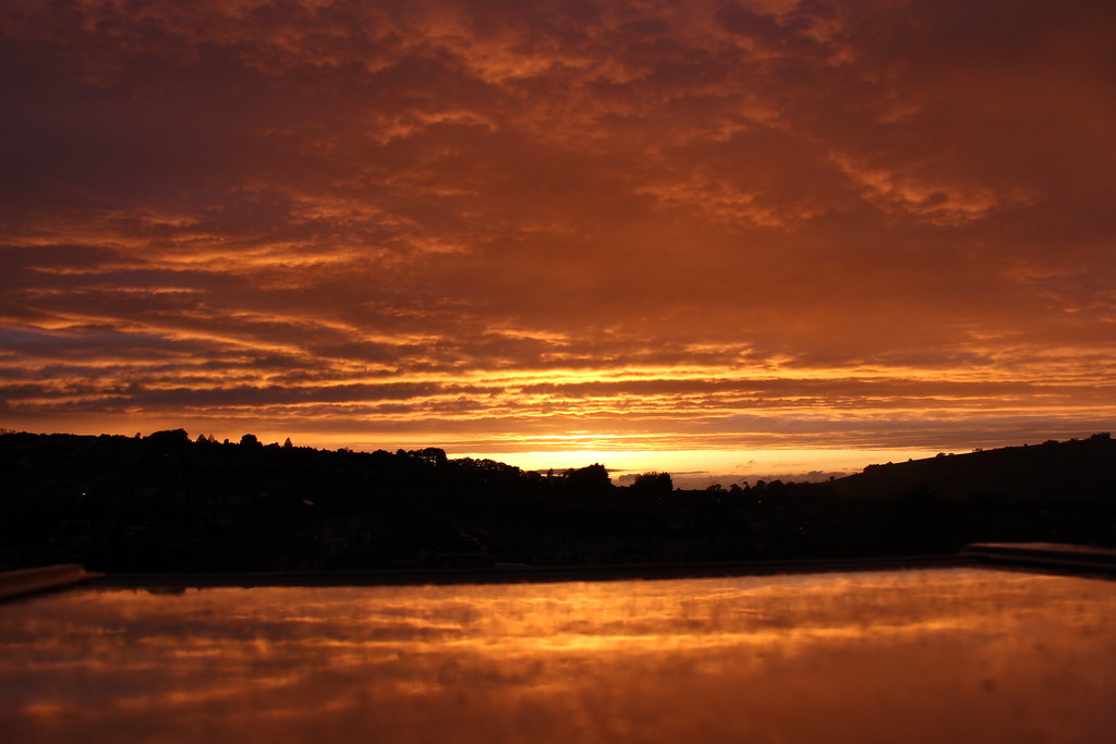 Tramonto con dominante arancione su cielo e acqua