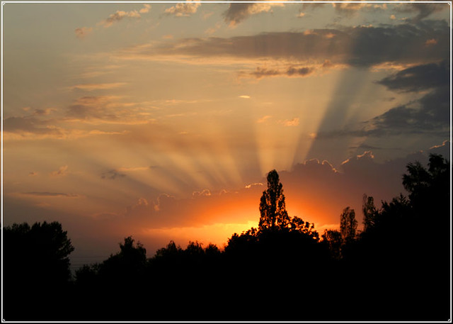 Tramonto con raggi solari mistici che squarciano il cielo