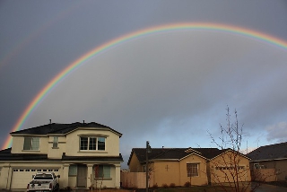 Arcobaleno ben delineato sopra le case