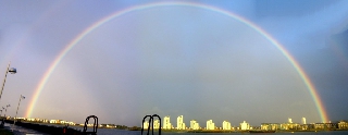 Arcobaleno gigantesco come cupola su città