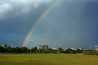 Arcobaleno sopra lampioni di città