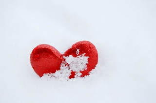 Cuore rosso verticale incastrato nella neve