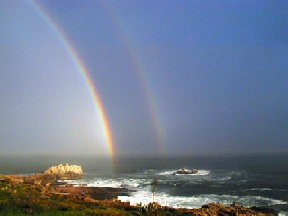 Doppio arcobaleno che nasce dal mare